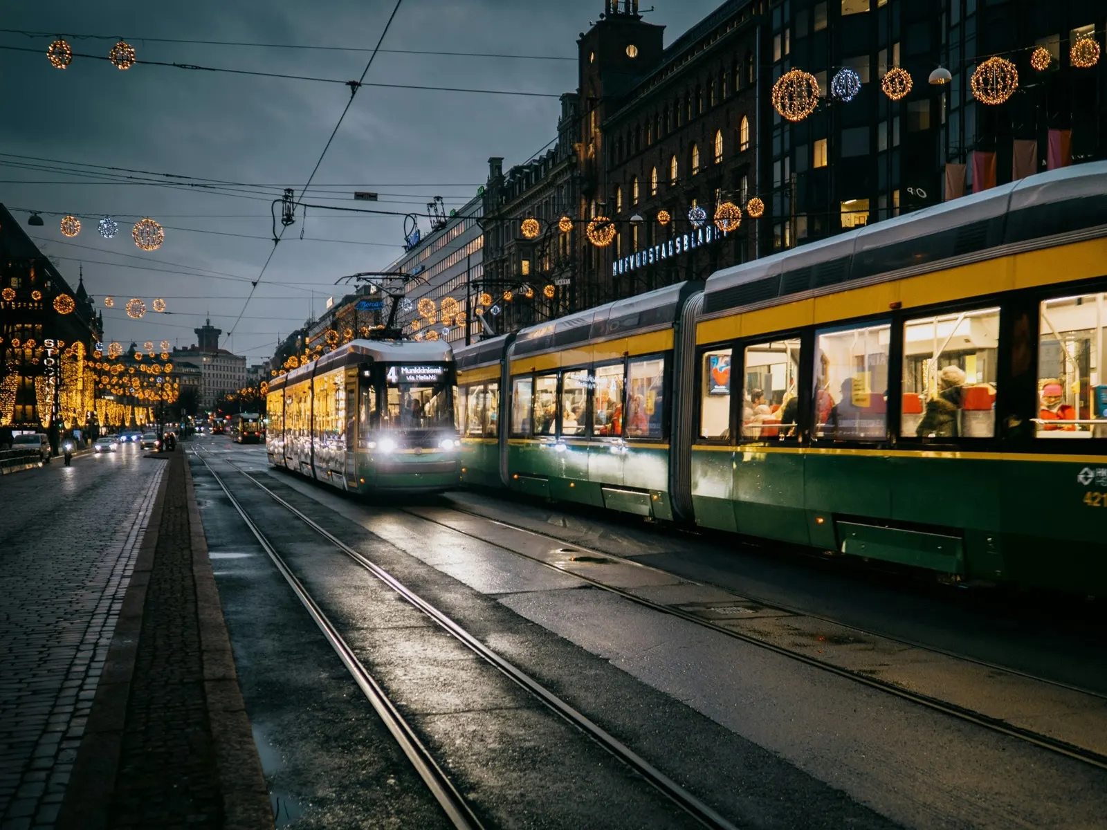 Raitiovaunuja Mannerheimintiellä Helsingissä illan valoissa